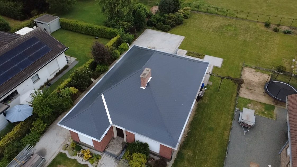 Dakrenovatie met leien in 40x27 formaat afgewerkt met stracord motief op de nokken en noorbomen